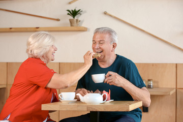 Happy senior couple sitting together in cafe