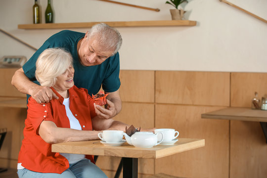 Happy senior couple sitting together in cafe