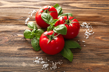 Fresh basil, tomatoes and salt on wooden background