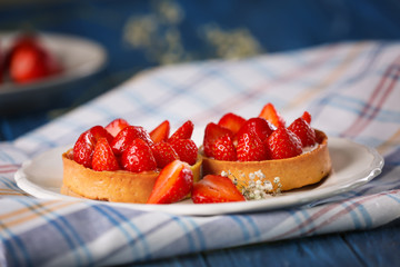 Tasty tartlets with strawberries on table