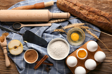 Utensils with bread and ingredients for preparing bakery on wooden table
