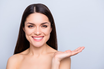 Advertisement choice advice recommend concept. Portrait of charming woman holding copyspace on palm isolated on grey background. Cream lotion vitamins detox scrub mask moisturizer concept