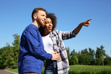 Young loving interracial couple outdoors on spring day