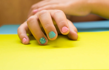 children's manicure in pastel colors on a pastel background