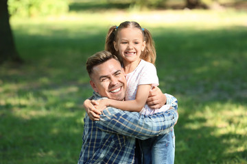 Fototapeta premium Portrait of father and daughter in green park