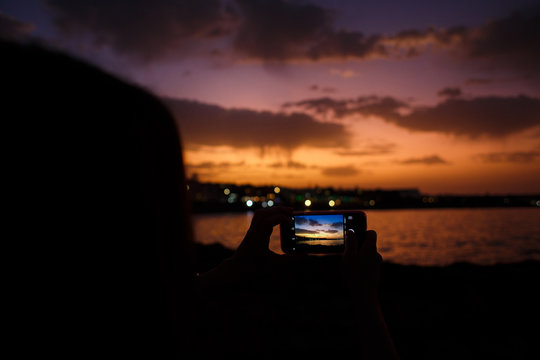  girl takes pictures of a beautiful sunset © Евгения Трастандецка