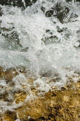  Waves beating against stones, blue water and scattering sprays