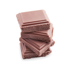 Delicious milk chocolate pieces on white background