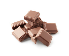 Delicious milk chocolate pieces on white background