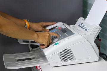 hand man are using a fax machine in the office. Business concept 