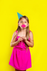 Studio portrait of a little girl wearing a party hat on her birthday.