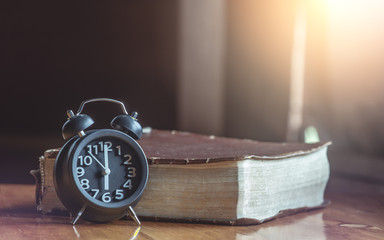 Clock and Bible on wood,How much the time of man given to God,christian concept.