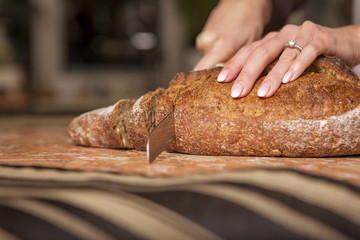 Beautiful young brunette woman in casual outfit cooking in the kitchen in her home. Luxury rich interior