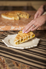 Beautiful young brunette woman in casual outfit cooking in the kitchen in her home. Luxury rich interior
