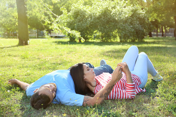 Happy couple lying on grass in park