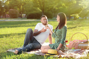Happy couple having picnic in park on spring day