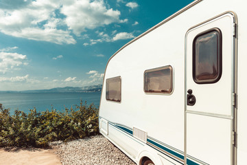 Caravan Trailer Near Sea, Beach And Blue Sky. Summer Holidays Road Trip Travel Concept