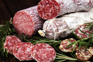 thinly sliced salami on a wooden texture on the background.