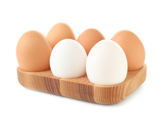 Wooden holder with chicken eggs on white background