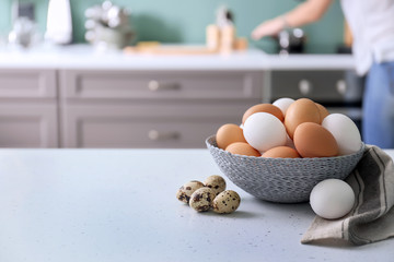 Wicker bowl with chicken eggs on kitchen table