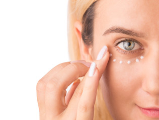 Eye cream treatment. Close up of green eye beautiful woman applying eye cream. Anti-aging and...