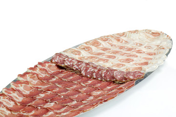 arrangement of delicatessen meat in a long tray on white background