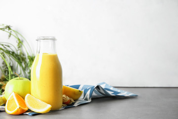 Bottle of fresh tasty smoothie and ingredients on table