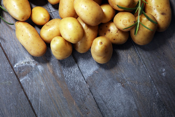 Pile of potatoes lying on wooden boards. Fresh potato