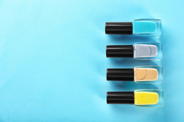 Bottles of nail polishes on color background