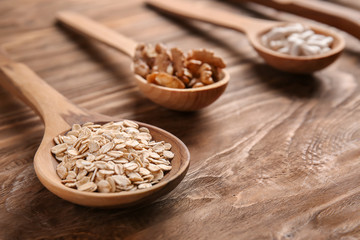 Spoon with oatmeal flakes on wooden table