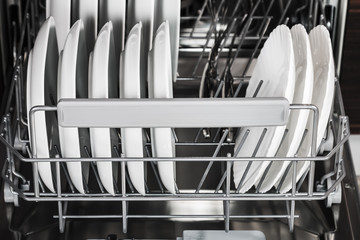 clean plates and different dishes in the dishwasher