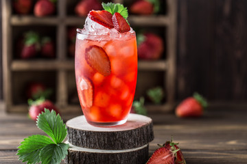Fresh strawberry cocktail. Fresh summer cocktail with strawberry and ice cubes. Glass of strawberry soda drink on dark background.