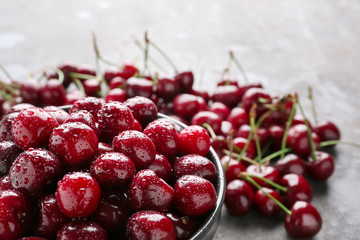 Bowl with tasty cherries on table, closeup