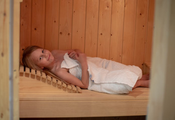 Ein Mädchen liegt in der Sauna