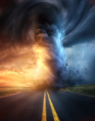 A powerful supercell storm at sunset producing a huge and destructive tornado touching down on a highway road. Mixed media illustration.