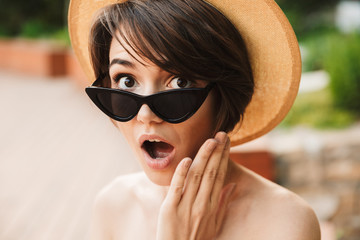 Close up of a surprised young girl in summer hat