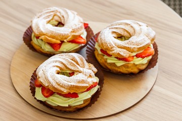 Obraz na płótnie Canvas Paris Brest, Cream puff rings with pistachio cream and fresh strawberry, traditional french choux pastry
