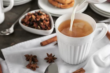 Fotobehang Adding milk to delicious tea on table © Pixel-Shot