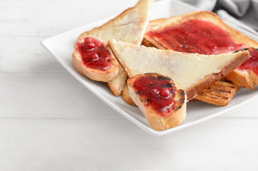 Tasty toasted bread with butter and sweet jam on plate