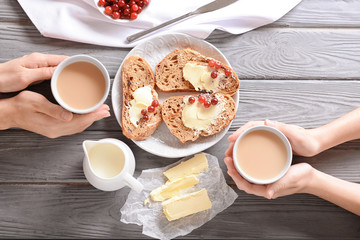 Women drinking tea with milk and delicious toasts, top view