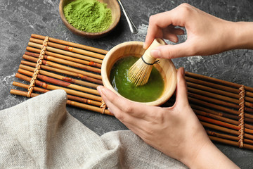 Woman preparing matcha tea, closeup