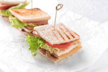 Tasty sandwiches with lettuce on white table