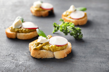Delicious toasts with radish on table