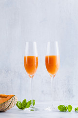 Italian Bellini alcoholic cocktail made from sweet ripe melon with basil flavor. Ideal drink for snacks