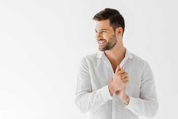 side view of smiling man in linen white shirt isolated on grey background
