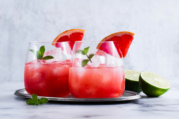 alcoholic cocktail Paloma of grapefruit and ice in glasses on a marble table . refreshing drink...