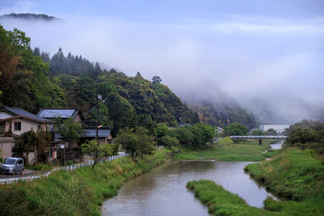 Fototapeta na wymiar Homes in a small village next to river in rural Japan