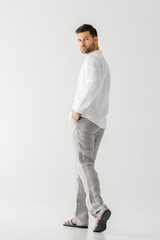 young handsome man in linen clothes posing isolated on grey background