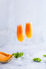 Italian Bellini alcoholic cocktail made from sweet ripe melon with basil flavor. Ideal drink for snacks