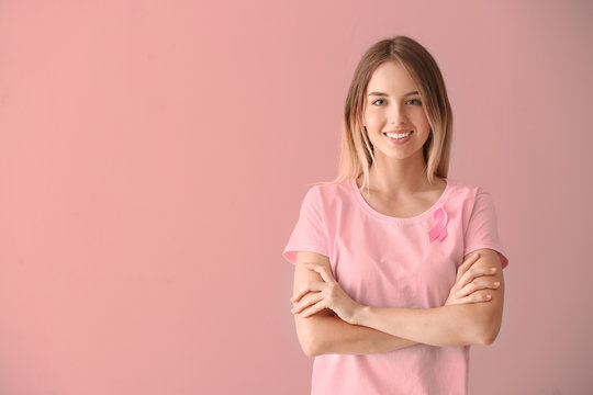 Beautiful Woman With Pink Ribbon On Color Background. Breast Cancer Concept